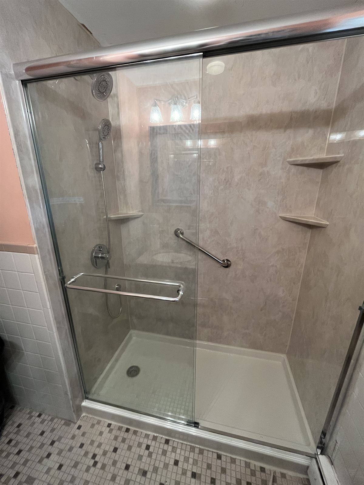 Travertine look acrylic tub and shower walls with glass panel and grab bar