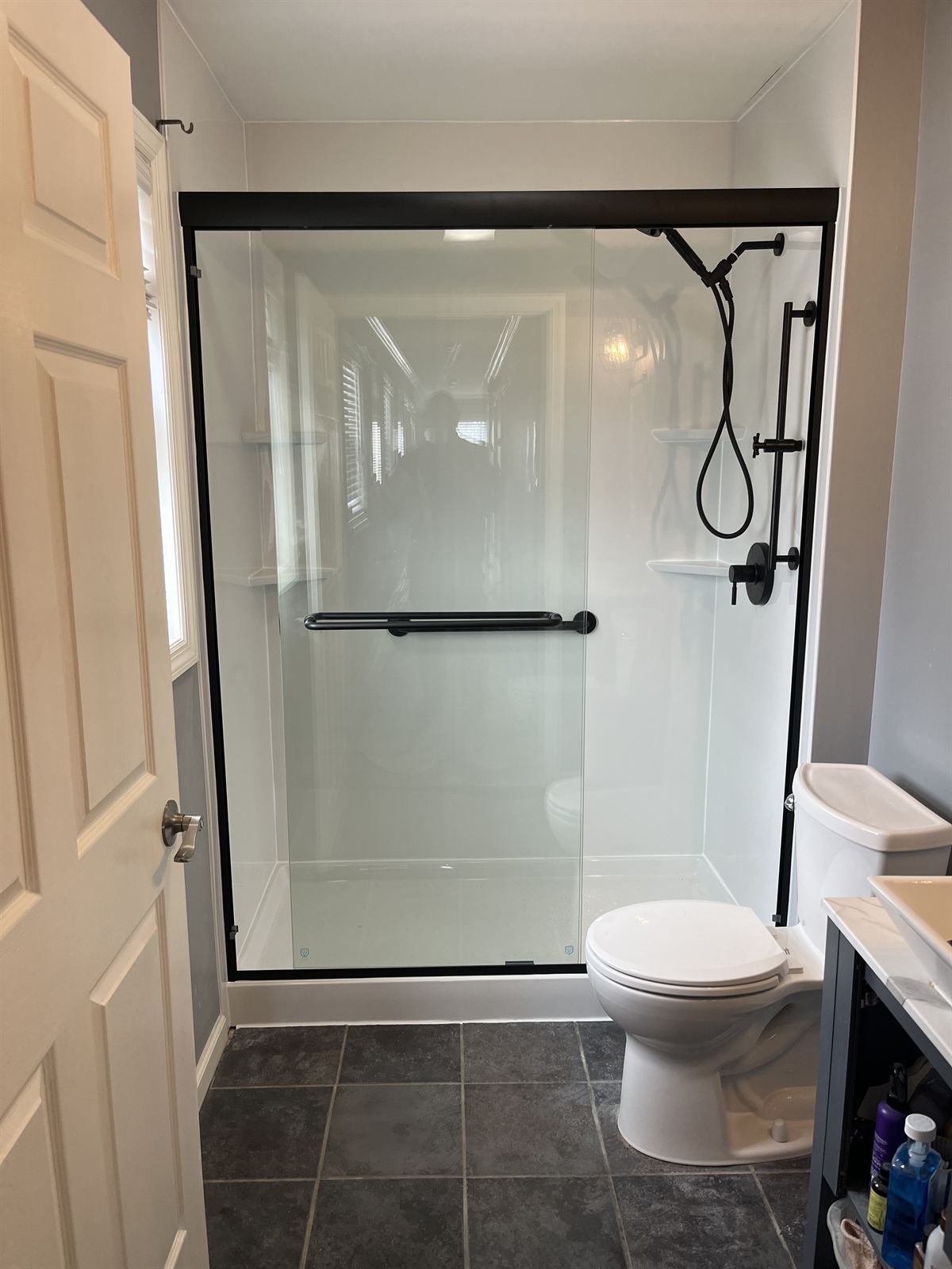 After: white acrylic shower with black framed glass and matte black fixtures