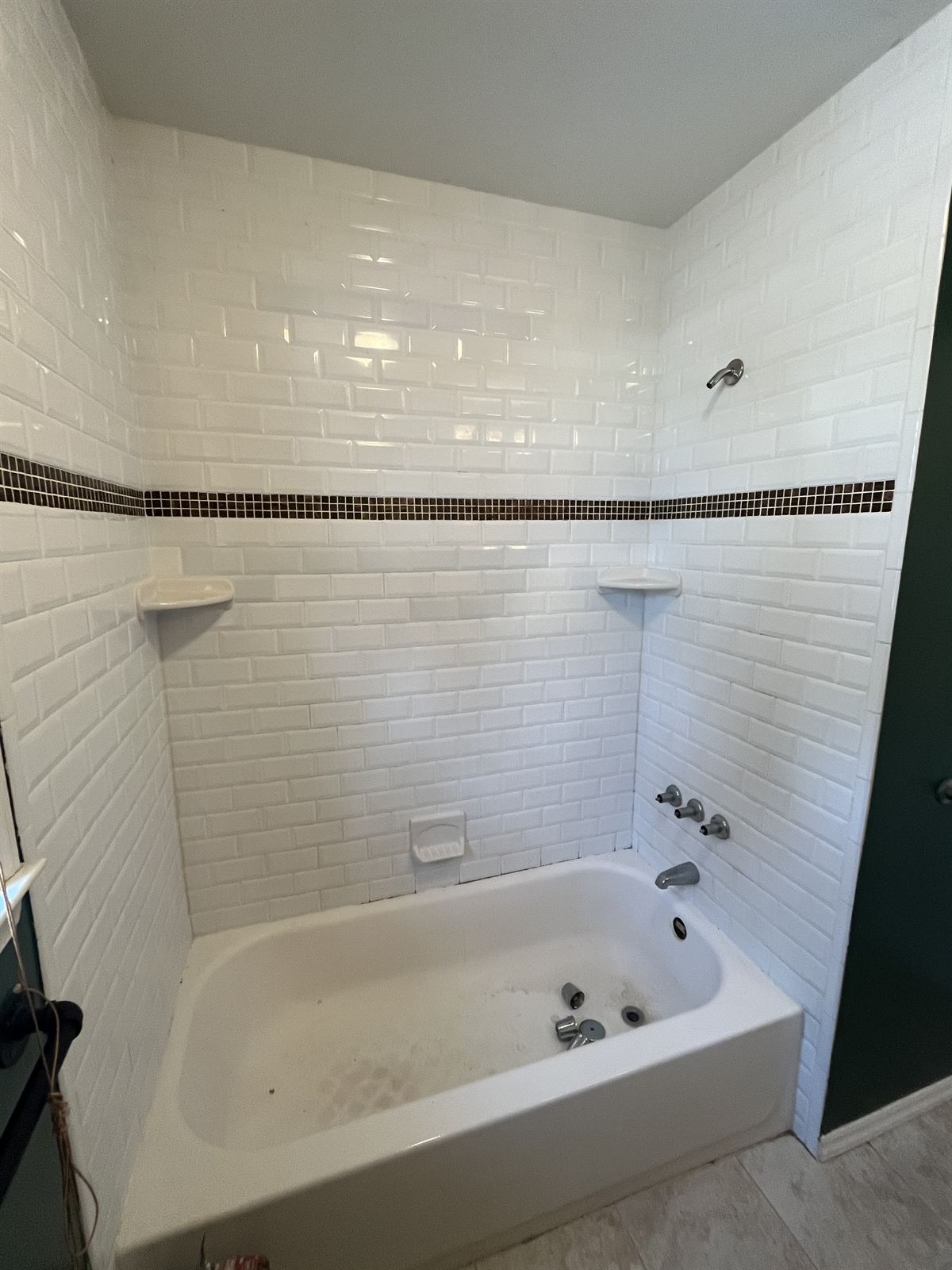 Before: stained tub with white subway tile