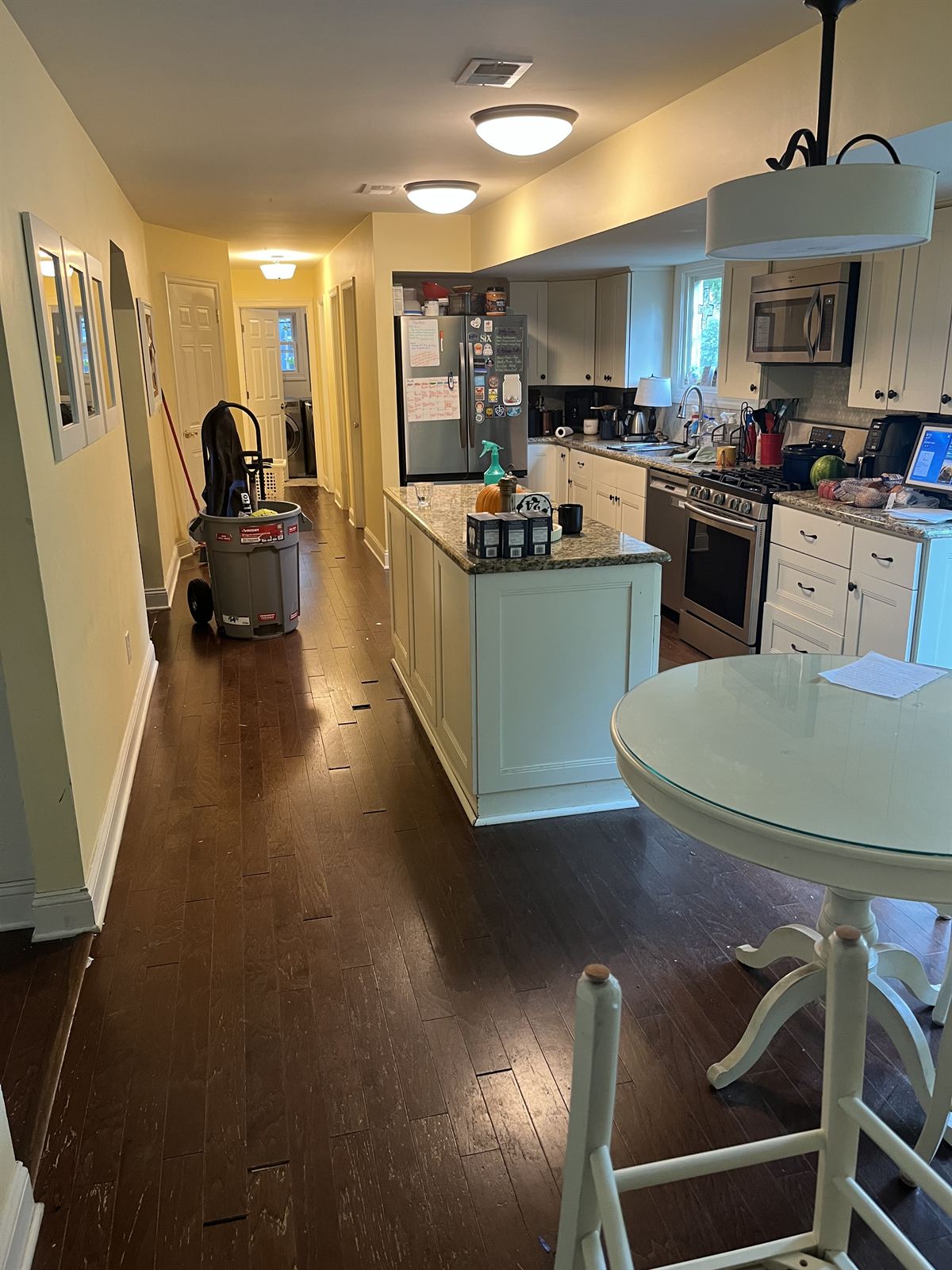 Before: the same kitchen and hallway with dark worn flooring