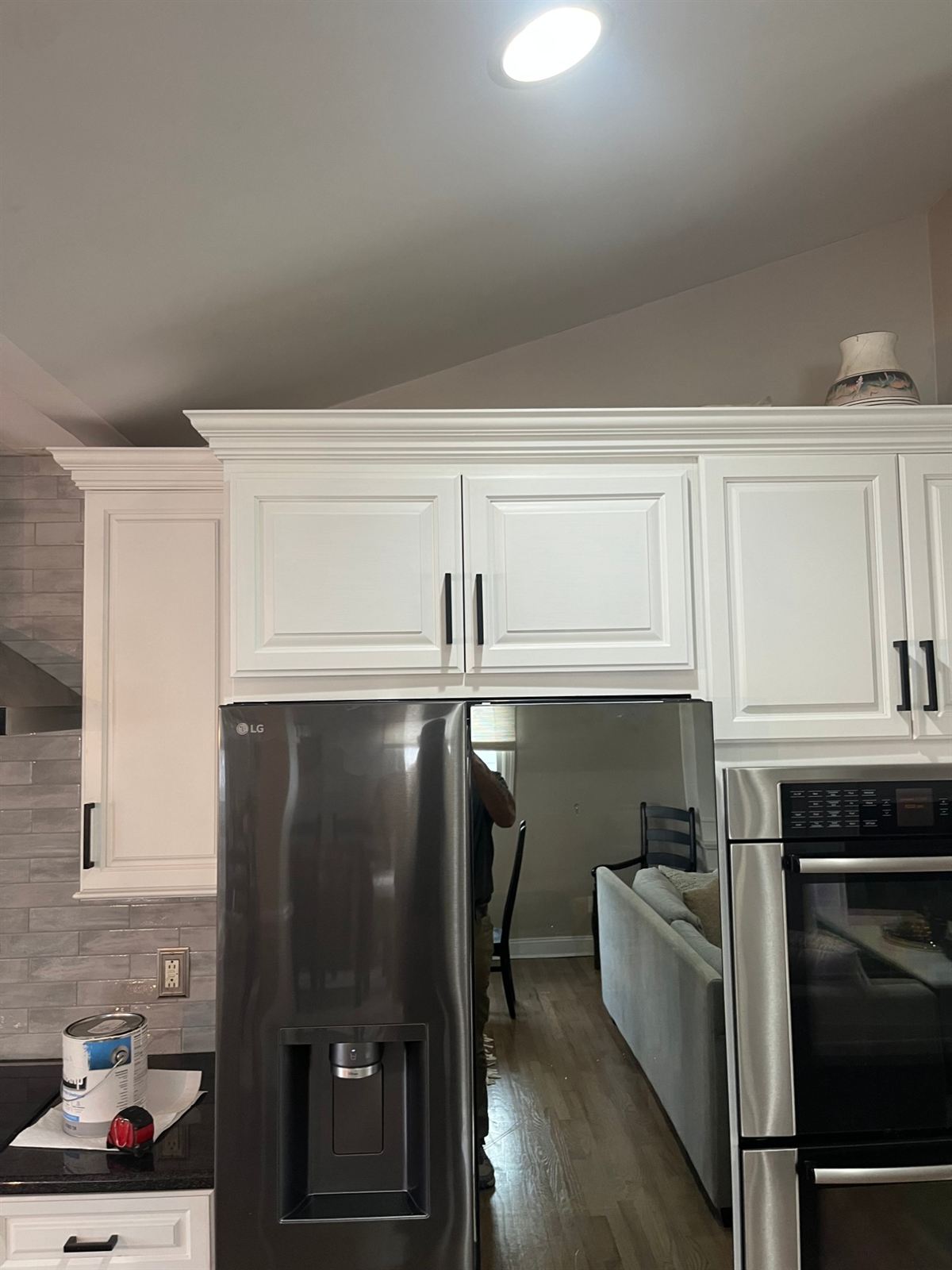 After: custom cabinet built on site above the fridge, blended into the existing cabinets with crown and matching hardware