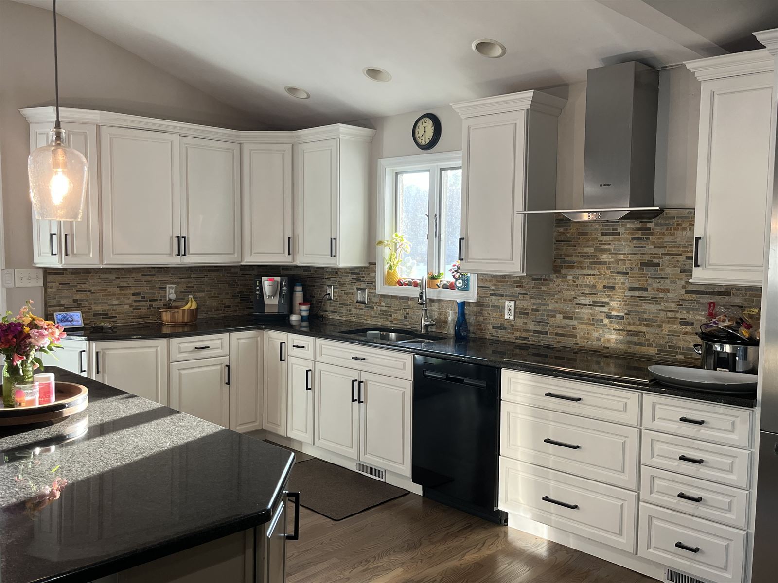 Before: busy multicolor stacked stone strip backsplash in the same kitchen